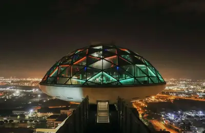 a view of the top of a building at night at Hyatt Regency Barcelona Tower in Hospitalet de Llobregat