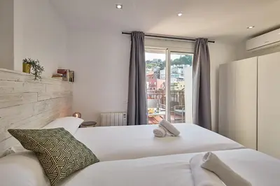 a bedroom with a white bed and a window at BBarcelona El Carmel Apartment with terrace in Barcelona