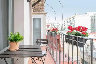 a balcony with a wooden bench and flowers on a balcony at My Space Barcelona - Newly renovated apartment in Gràcia for families and executives in Barcelona