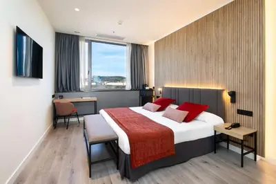 a hotel room with a large bed with red pillows at Alexandre Fira Congress in Hospitalet de Llobregat