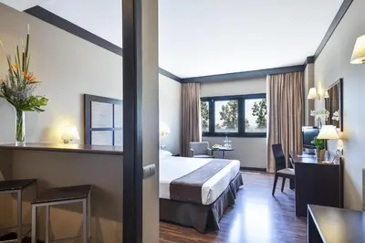 a hotel room with a bed and a desk at Aparthotel Attica 21 Vallés in Sabadell