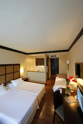 a hotel room with two beds and a desk at Aparthotel Attica 21 Vallés in Sabadell