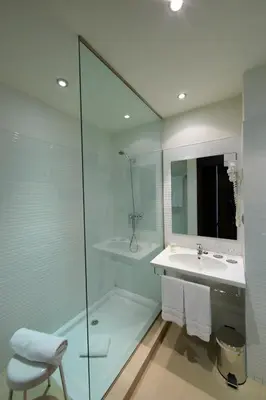 a bathroom with a sink and a glass shower at Aparthotel Attica 21 Vallés in Sabadell