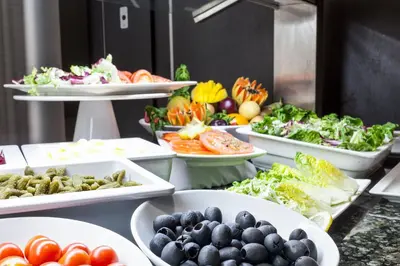 a buffet with plates of food on a table at Aparthotel Attica 21 Vallés in Sabadell