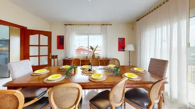 a dining room with a wooden table and chairs at VILLA VALENTINA in Mataró