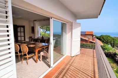 a balcony with a table and a dining room at VILLA VALENTINA in Mataró