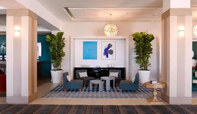 a lobby with a waiting area with chairs and a table at Eurostars Sitges in Sitges