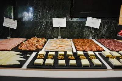 a display of different types of meats and cheese at Aparthotel Atenea Valles in Granollers