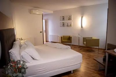 a bedroom with a bed with white sheets and pillows at Hotel Bruc in El Bruc