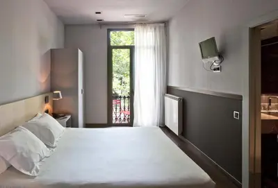 a bedroom with a large white bed and a window at Chic & Basic Zoo in Barcelona