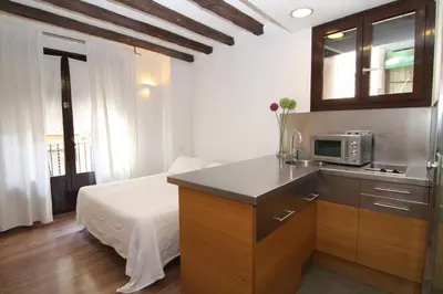 a kitchen with a microwave and a bed in a room at BCN2STAY Apartments in Barcelona