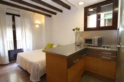 a kitchen with a microwave and a bed in a room at BCN2STAY Apartments in Barcelona