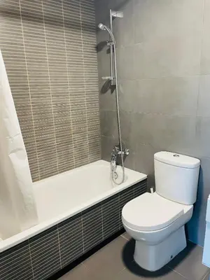 a bathroom with a toilet and a bath tub at Fira de Barcelona City View Apartment with Garage Parking in Hospitalet de Llobregat