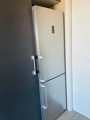 a stainless steel refrigerator sitting in a kitchen at Fira de Barcelona City View Apartment with Garage Parking in Hospitalet de Llobregat