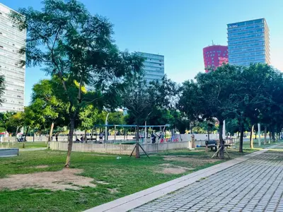 a park with trees and a sidewalk and buildings at Fira de Barcelona City View Apartment with Garage Parking in Hospitalet de Llobregat