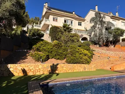 a house with a swimming pool in front of a house at Sunny forest Villa near Barcelona in Vallirana