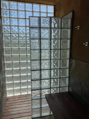 a glass wall in a room with a bench at Sunny forest Villa near Barcelona in Vallirana