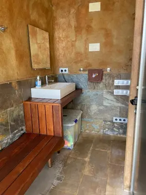 a bathroom with a sink and a counter with a bench at Sunny forest Villa near Barcelona in Vallirana