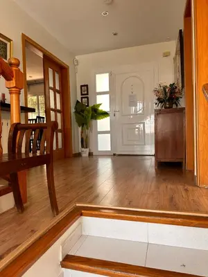 a living room with a wooden floor and a dining room at Sunny forest Villa near Barcelona in Vallirana