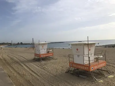 two lifeguard stations on a beach with the water at Standing Apartment Barcelona Forum in Sant Adria de Besos