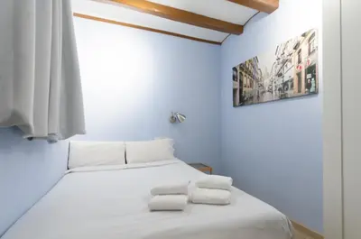 a bedroom with a white bed with two towels on it at Homenfun Barcelona Eixample I in Barcelona
