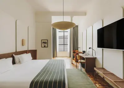 a hotel room with a bed and a flat screen tv at Hotel Regina Barcelona in Barcelona