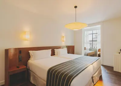 a bedroom with a large bed with a striped blanket at Hotel Regina Barcelona in Barcelona