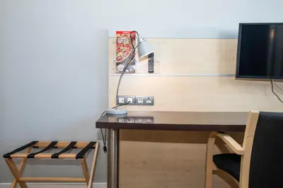a desk with a lamp and a monitor and a chair at Holiday Inn Express Barcelona - Montmeló by IHG in Granollers