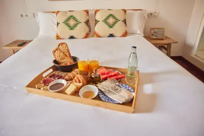 a tray of breakfast food on a bed at Hotel Palou 1874 in Sant Pere de Ribes