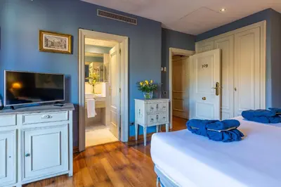 a room with two beds and a television and a bathroom at Hotel Blancafort Spa Termal in La Garriga
