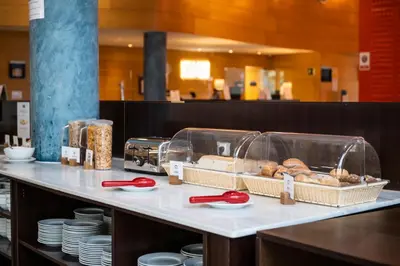 a counter with some pastries and plates on it at Holiday Inn Express Molins de Rei by IHG in Molins de Rei