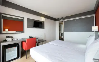 a hotel room with a bed and a desk and a tv at Medplaya Hotel Santa Monica in Calella