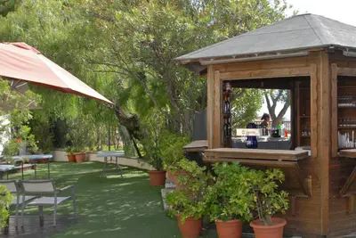 a wooden building with a bar in a garden at Hotel El Castell in Sant Boi del Llobregat