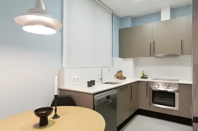 a small kitchen with a wooden table and a lamp at Señor Urgell Apartment by Olala Homes in Barcelona
