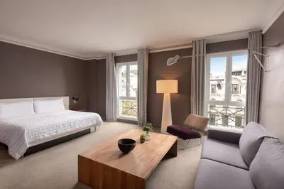 a hotel room with a bed and a couch at Le Meridien Barcelona in Barcelona
