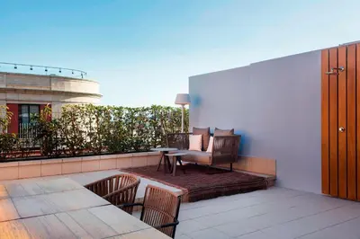 a patio with a table and chairs on a balcony at Le Meridien Barcelona in Barcelona