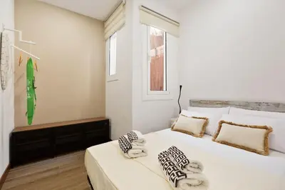 a white bedroom with a large white bed with pillows at Bright Apt with Private Terrace in Sant Antoni in Barcelona