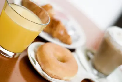 a plate of donuts and a glass of orange juice at Hotel Ciutat De Sant Adria in Sant Adria de Besos