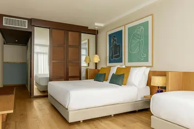 a hotel room with two beds and paintings on the wall at Sabàtic Gavà Mar, Barcelona, a Tribute Portfolio Hotel in Gavà