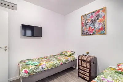 a room with two beds and a tv on the wall at Magic Badalona House in Badalona