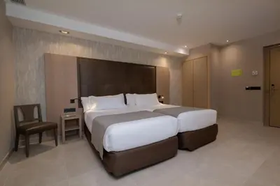 a hotel room with two beds and a couch at Gran Hotel Barcino 4 Estrellas SUPERIOR in Barcelona