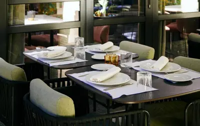 a table in a restaurant with white plates and napkins at Catalonia Boulevard in Barcelona
