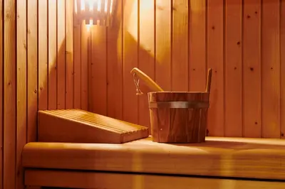 a sauna with a bucket next to a wooden wall at Catalonia Boulevard in Barcelona