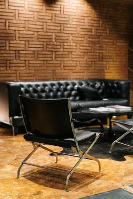 a black chair in front of a black couch at Hotel Granados 83, a member of Preferred Hotels & Resorts in Barcelona