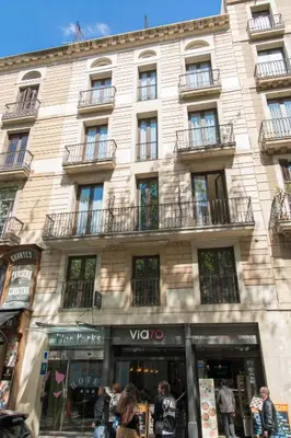 a building with people walking in front of it at Flor Parks in Barcelona