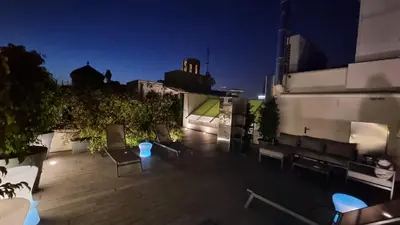 a rooftop patio at night with chairs and tables at Flor Parks in Barcelona