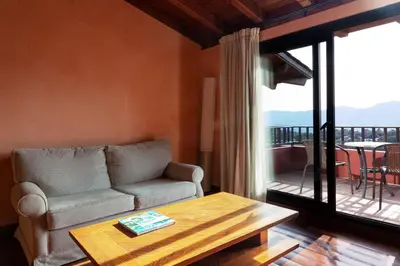 a living room with a couch and a table and a balcony at Montanyà in Seva