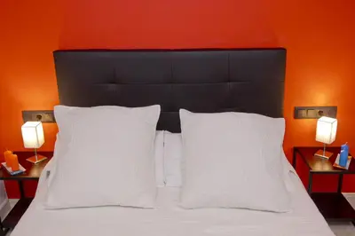 a bed with a black headboard and two white pillows at Barcelona City Centre Hostal in Barcelona