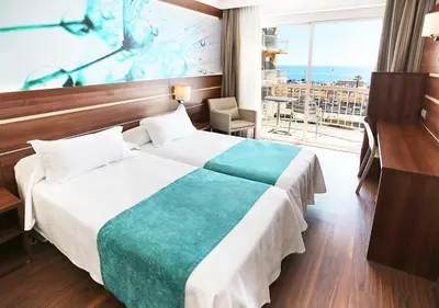 a hotel room with a bed and a view of the ocean at KAKTUS Hotel Volga in Calella