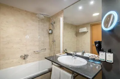a bathroom with a sink and a shower at Occidental Atenea Mar - Adults Only in Barcelona
